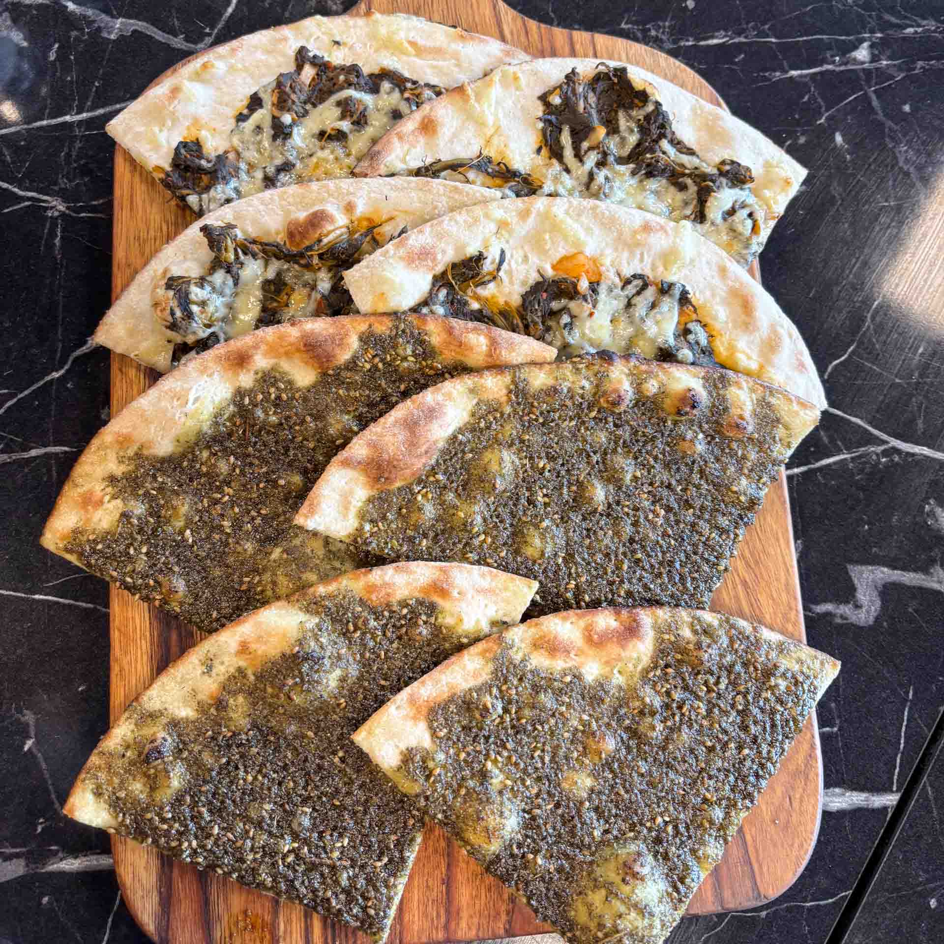 Hjemmebagte manakish med za'atar og spinat-ost serveret hos Zyara